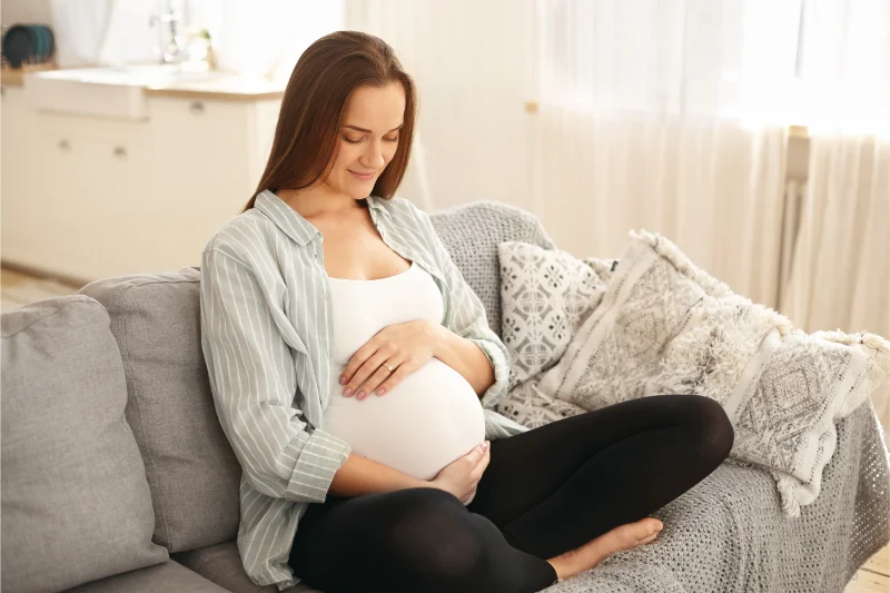 Pregnant woman gently touching her baby bump, chiropractic care during pregnancy.