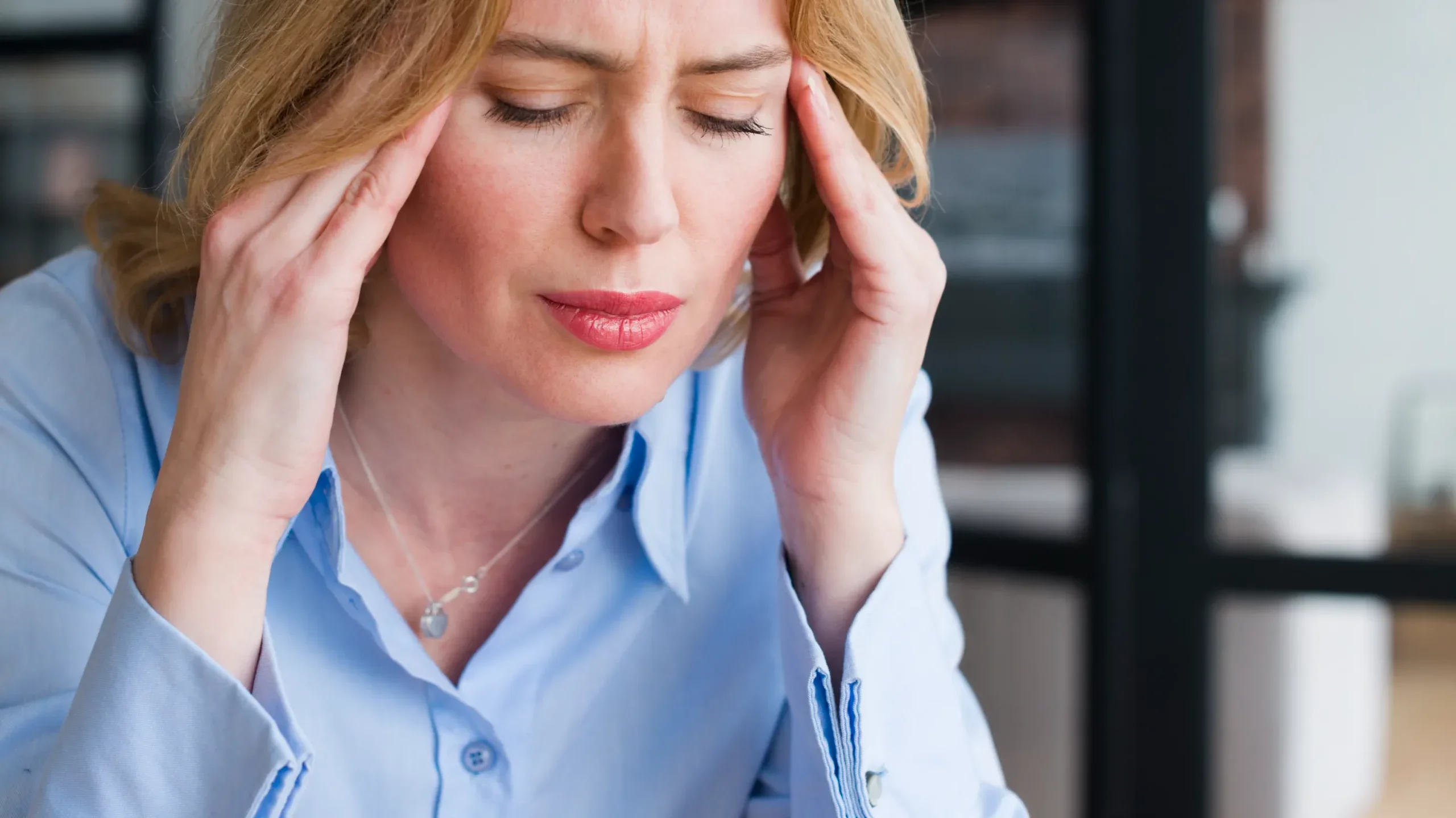 Woman experiencing headache pain, illustrating migraine symptoms and chronic headache relief.