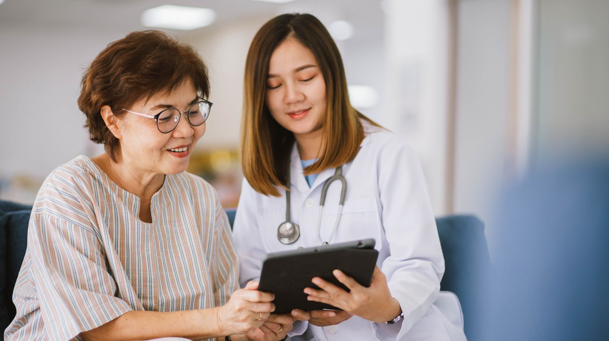 Doctor and patient discussing nervous system care and treatment options with tablet.
