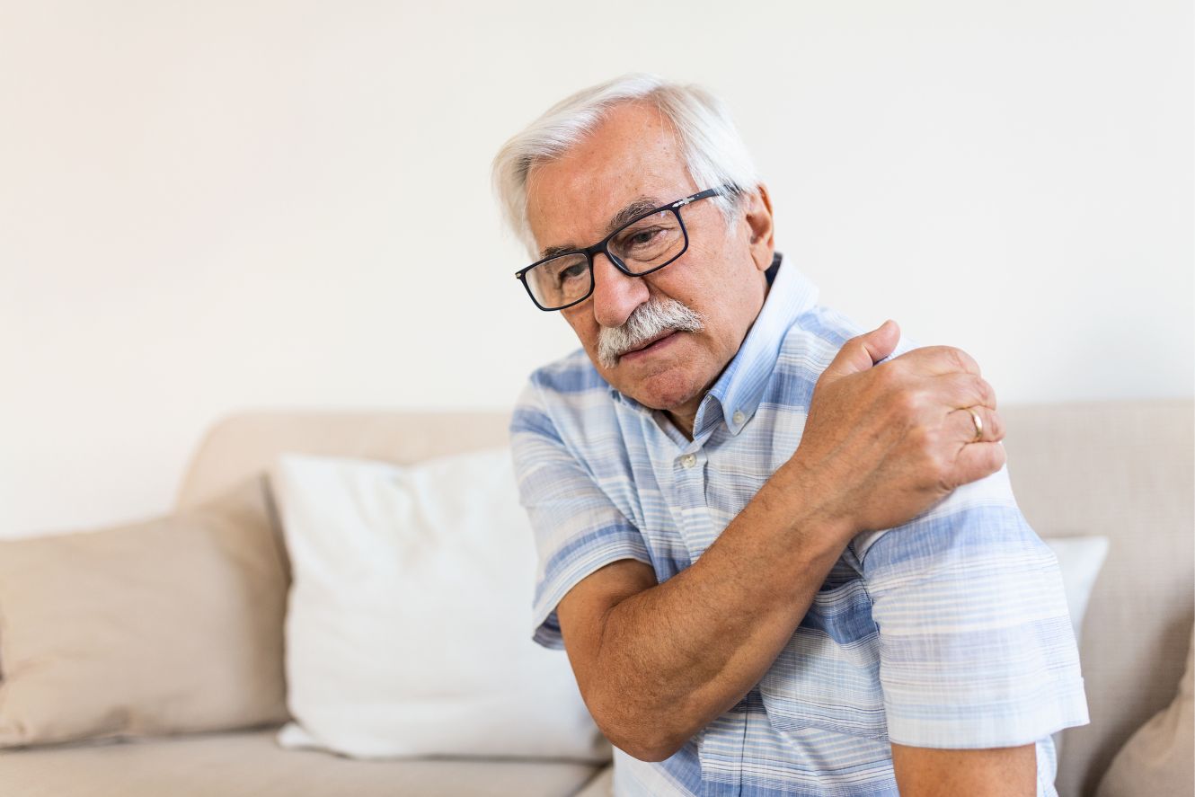 Elderly man experiencing shoulder pain and discomfort.
