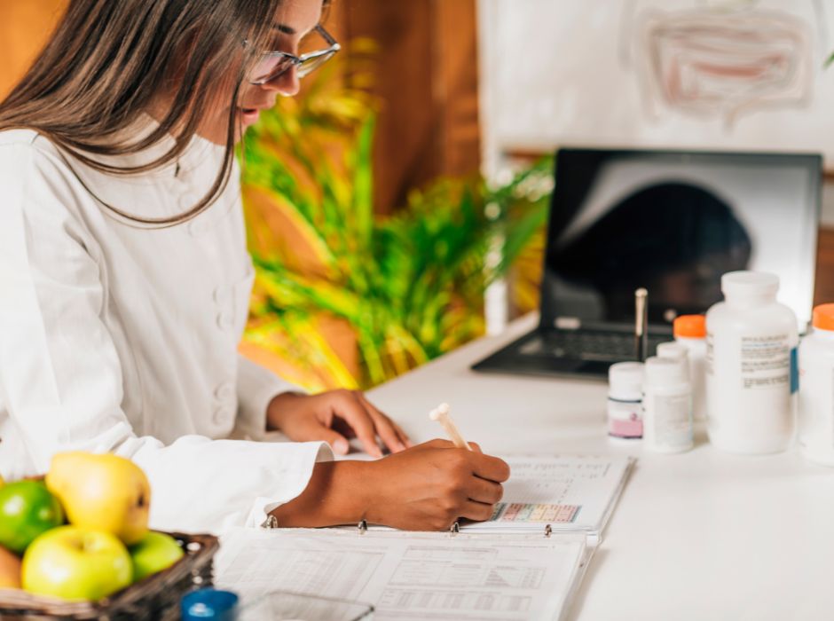 Woman examining patient records and medication bottles for rehabilitative therapy and chiropractic care.