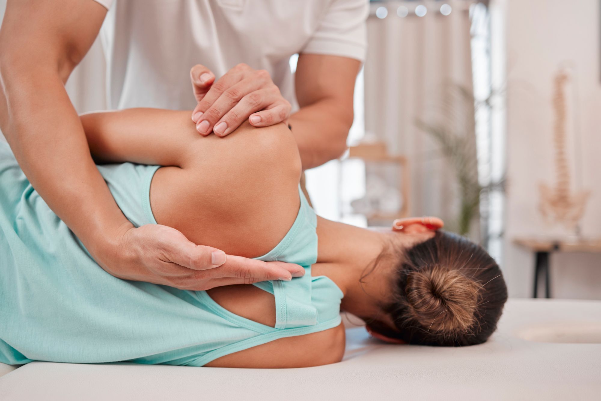 Chiropractor performing gentle spinal adjustment on patient's back, demonstrating Gonstead Technique.