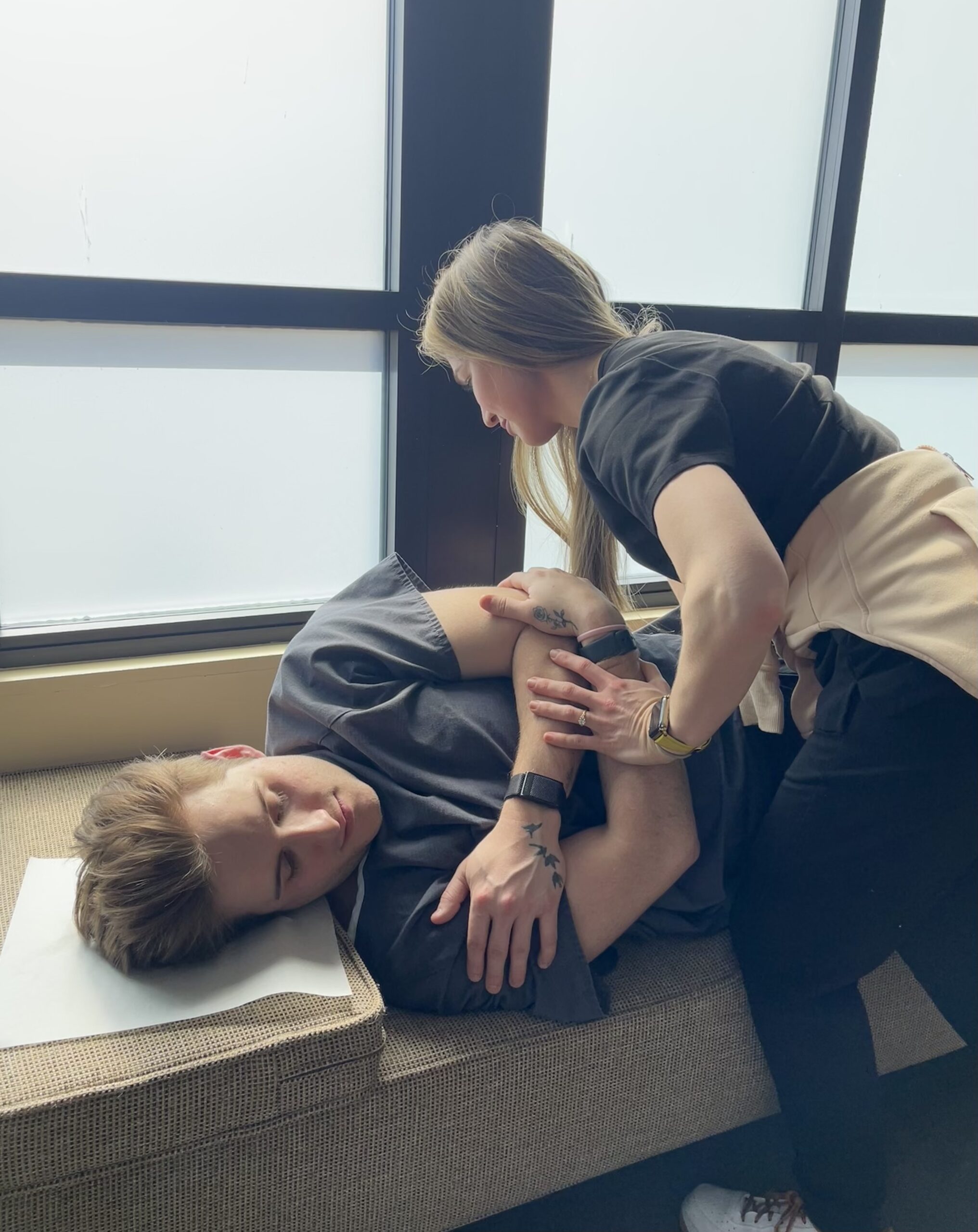 Chiropractor adjusting patient's leg demonstrating passive care and joint motion restoration.